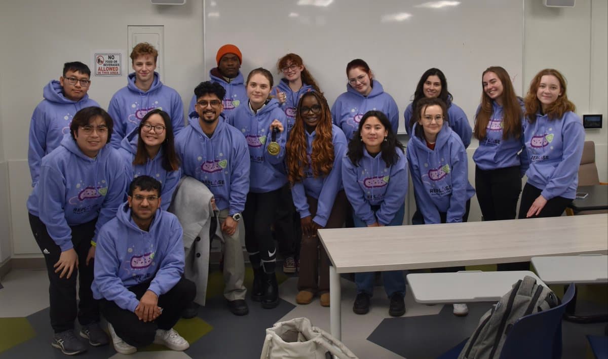 Prairie iGEM team members posing together in matching hoodies.